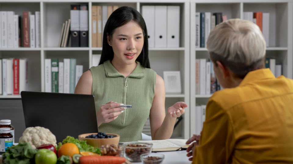 Une nutritionniste expliquant des conseils diététiques à une patiente lors d'une consultation. 