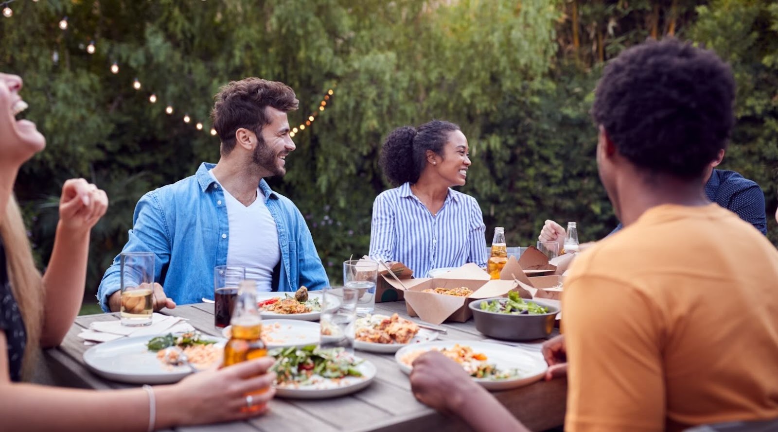 Multicultural friends at home, enjoying a meal at a summer garden party in Toronto Markham.