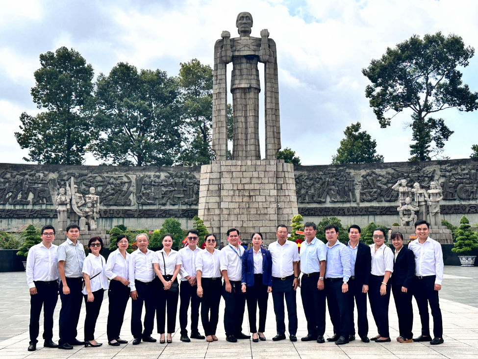 A group of people posing for a photo in front of a statueDescription automatically generated