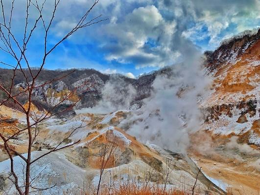 A mountain with steam coming out of itDescription automatically generated