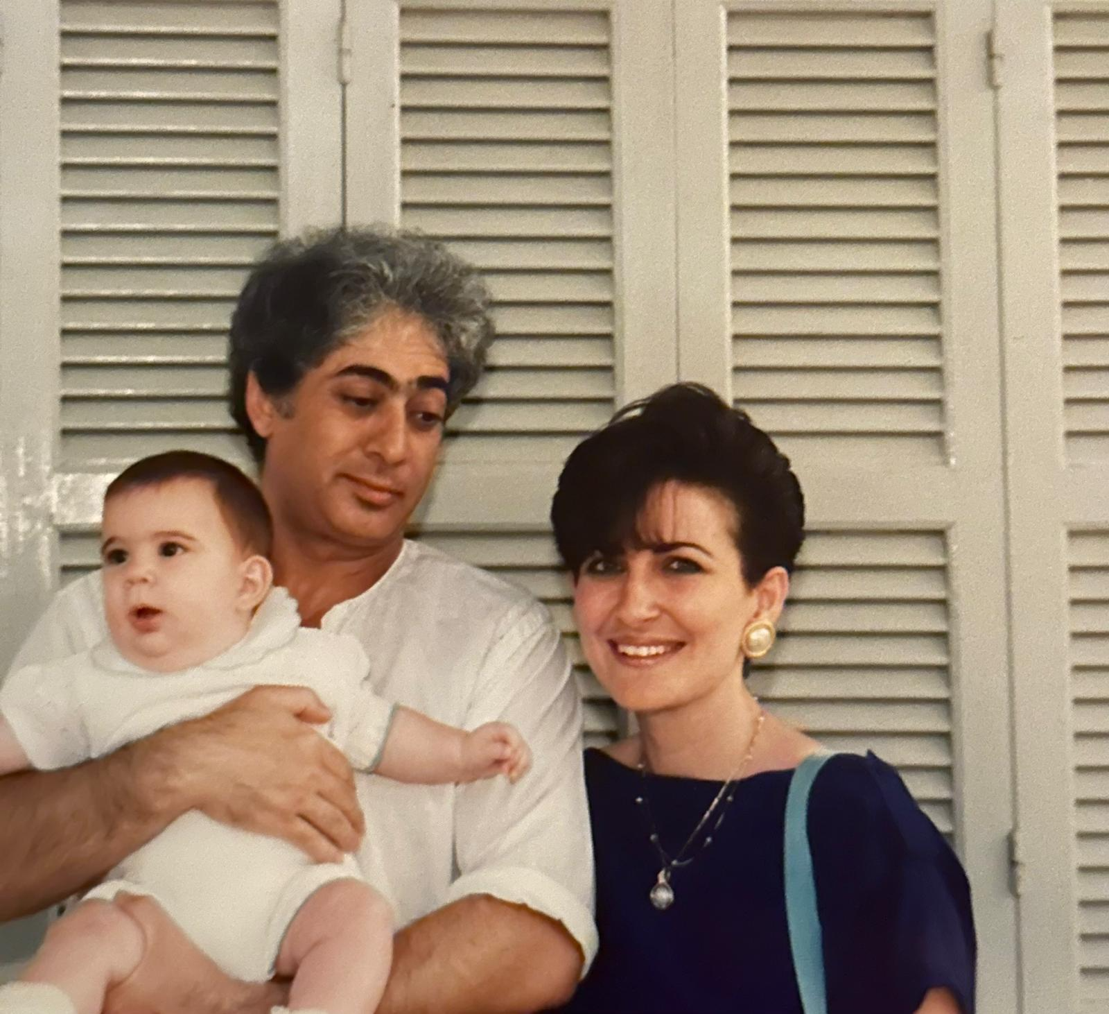 A person and person posing for a picture with a baby

Description automatically generated