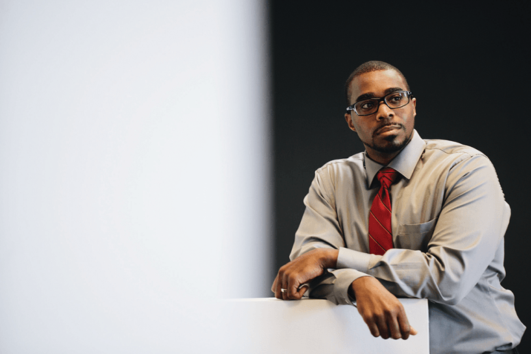 A photo of Dr. Rashawn Ray in a grey, long-sleeve business shirt with a red tie. Dr. Ray is a sociologist and professor at the University of Maryland.