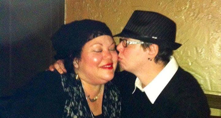 Wendy Lovedge smiles happily as her wife kisses her on the cheek.