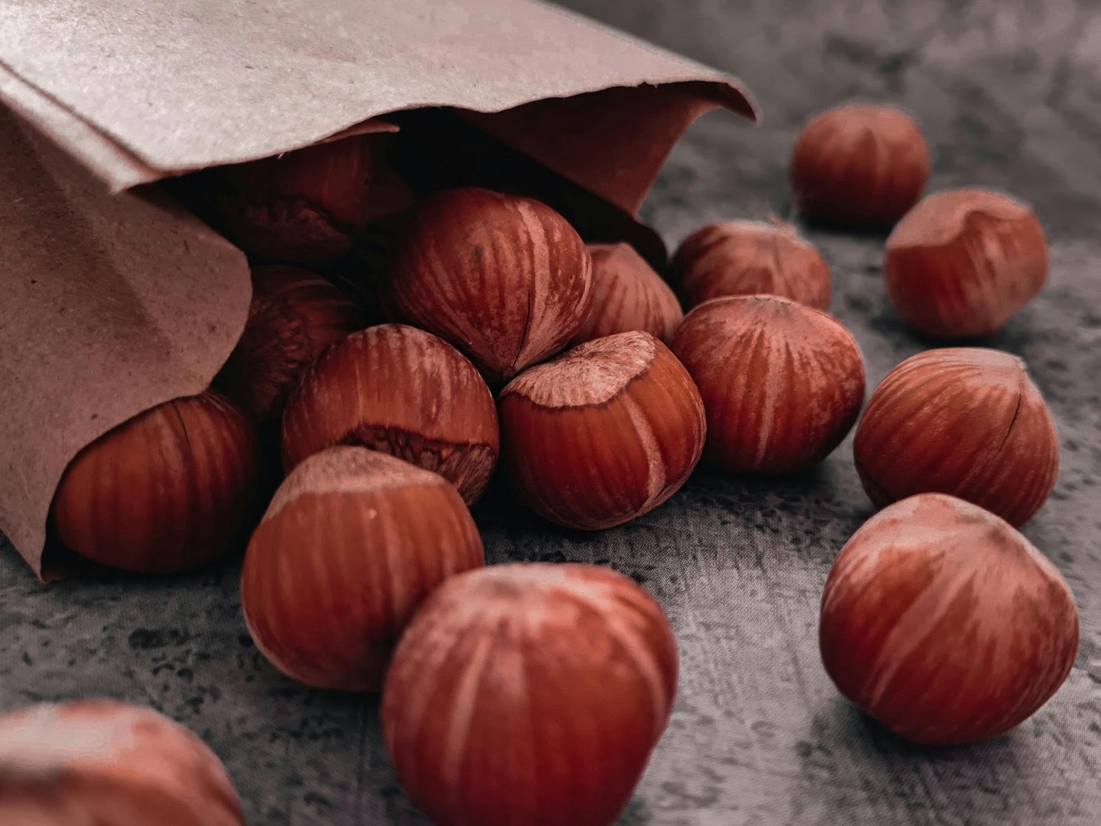 Brown hazelnuts spilling from a paper bag