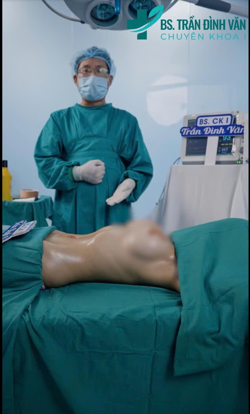 A person in a surgical gown and mask standing next to a person in a hospital bedAI-generated content may be incorrect.