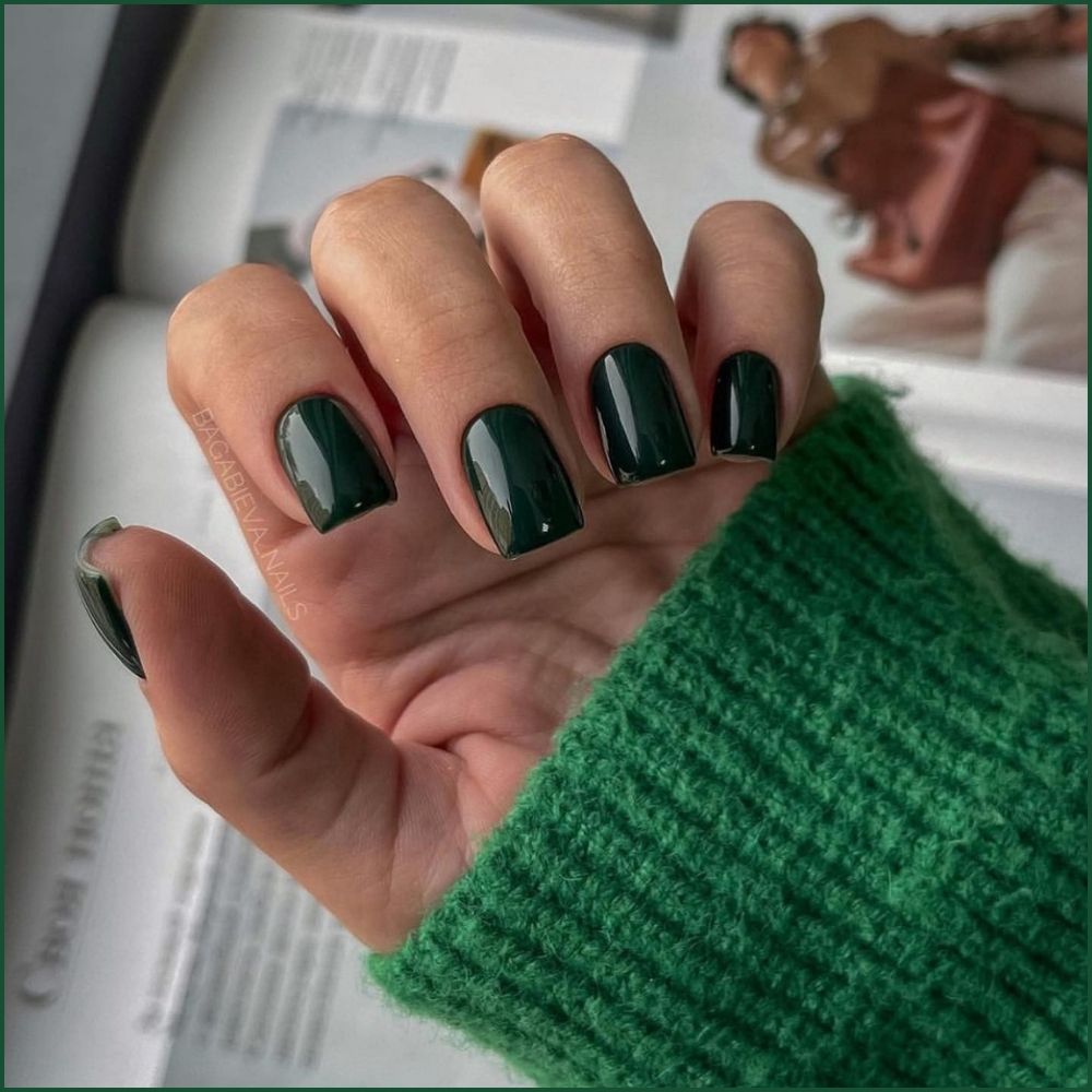 Close up of hands with Christmas Green Nails having  Dark Green Christmas Nails