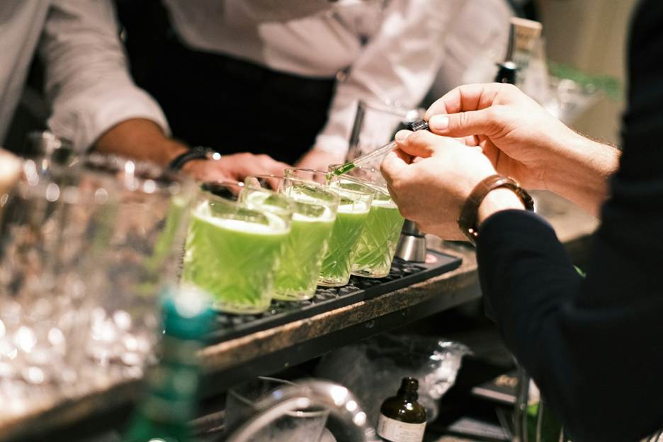 A close-up of a person pouring green liquid into glasses

AI-generated content may be incorrect.