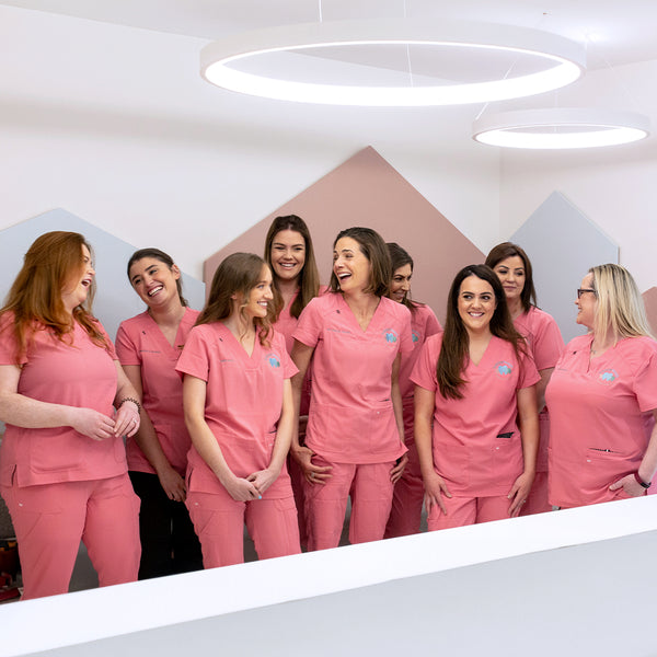 Dental team in pink scrubs