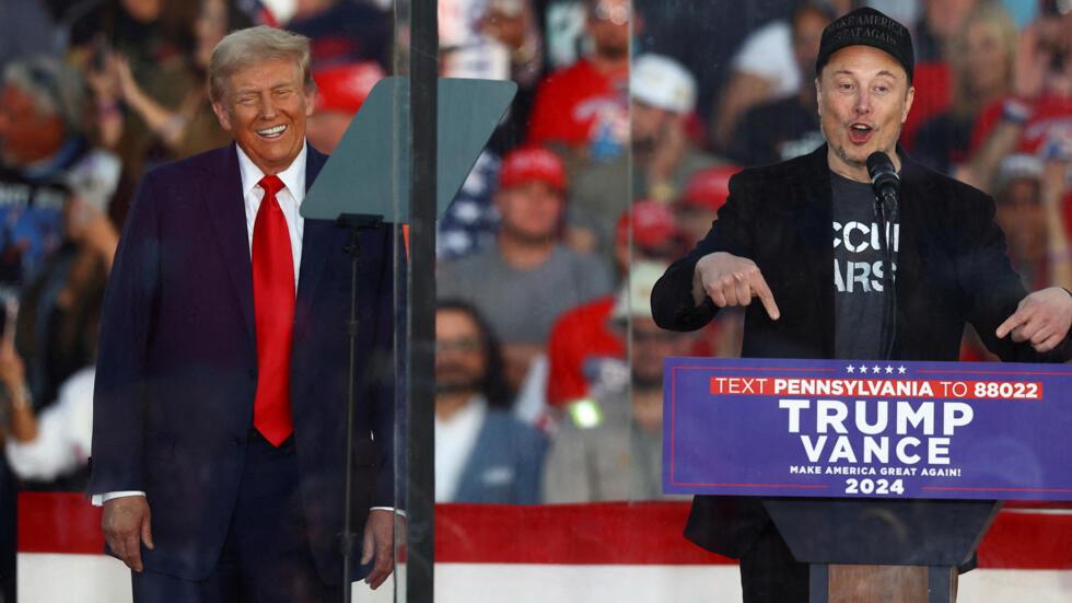 Tesla CEO and X owner Elon Musk speaks as Republican presidential nominee and former U.S. president Donald Trump reacts during a rally at the site of the July assassination attempt against Trump, in B