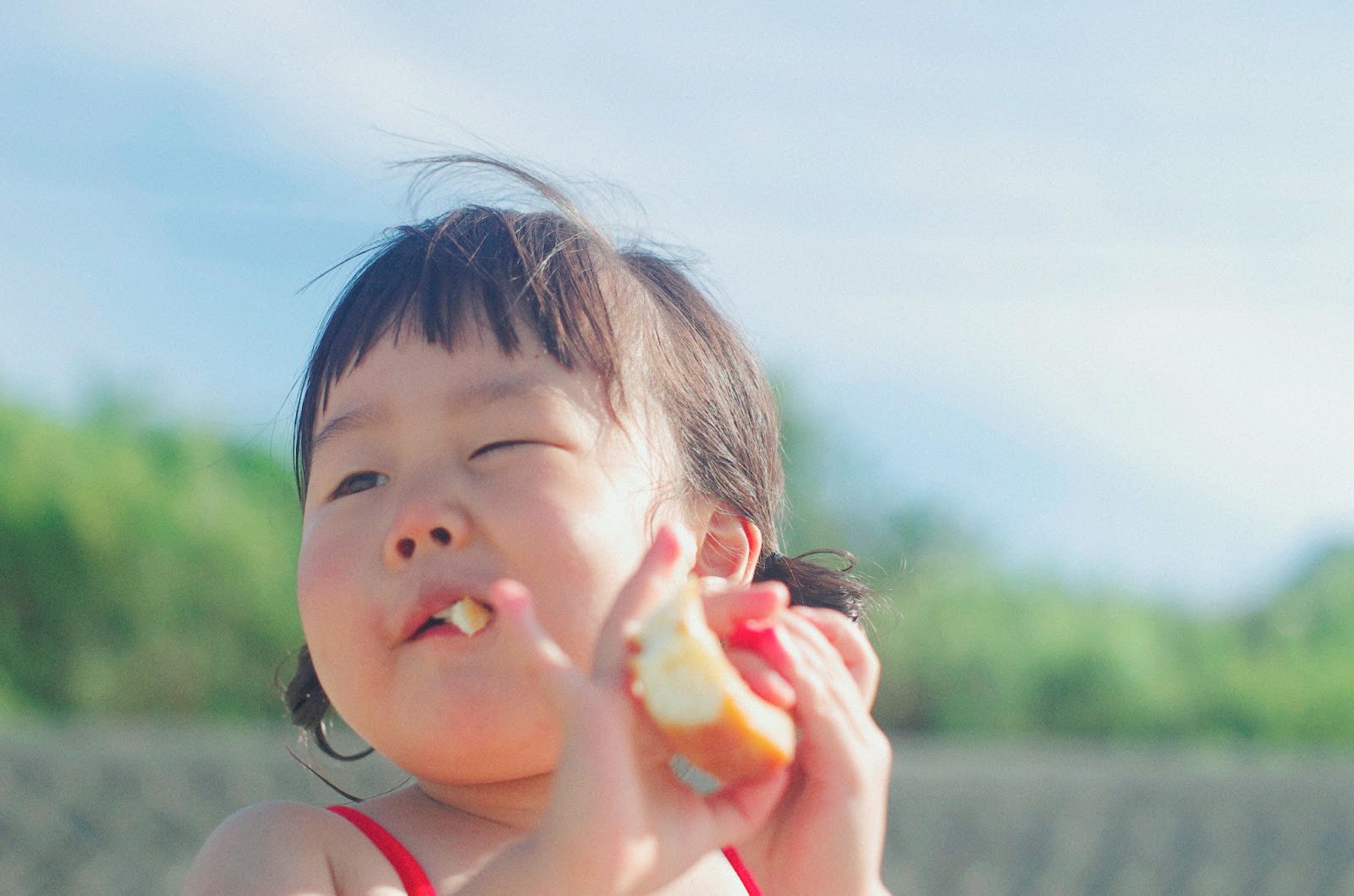 A Baby girl eating a bread