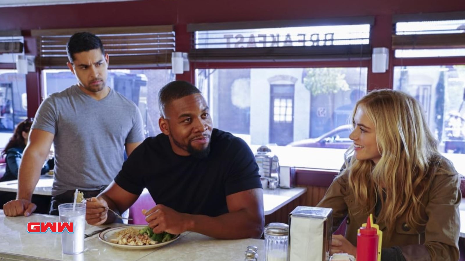 Nick, Clayton, and Ellie having a discussion at a diner.