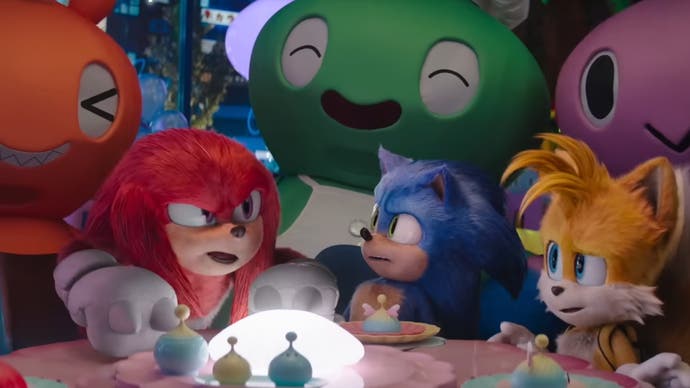 Cuplikan layar trailer Sonic the Hedgehog 3 yang memperlihatkan Knuckles Sonic dan Tails duduk di kafe bertema Chao