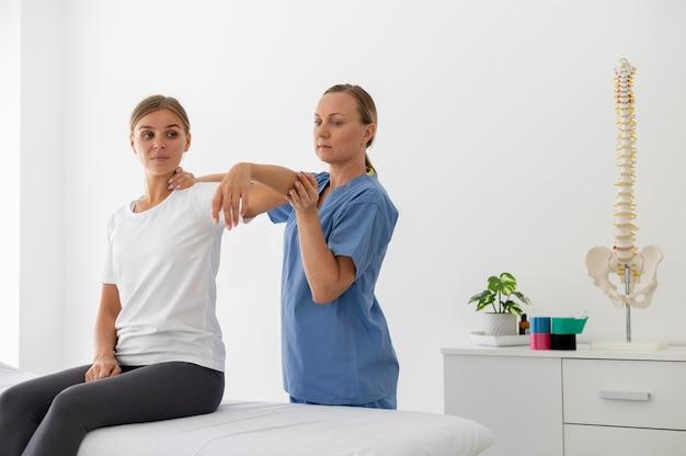 Physiotherapist helping a young female patient at her clinic