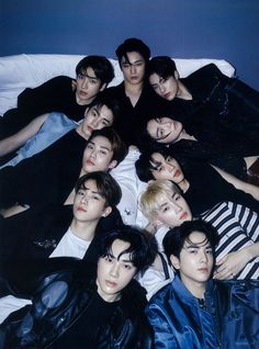 This containTHE BOYZ  laying next to each other on top of a white bed