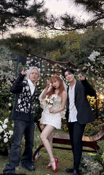 A photo of HyunA and Yong Junhyung on their wedding day with a friend