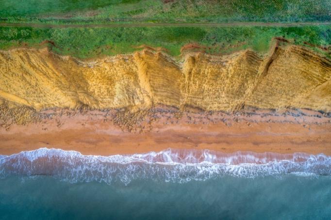 A beach with waves crashing on the shore

Description automatically generated