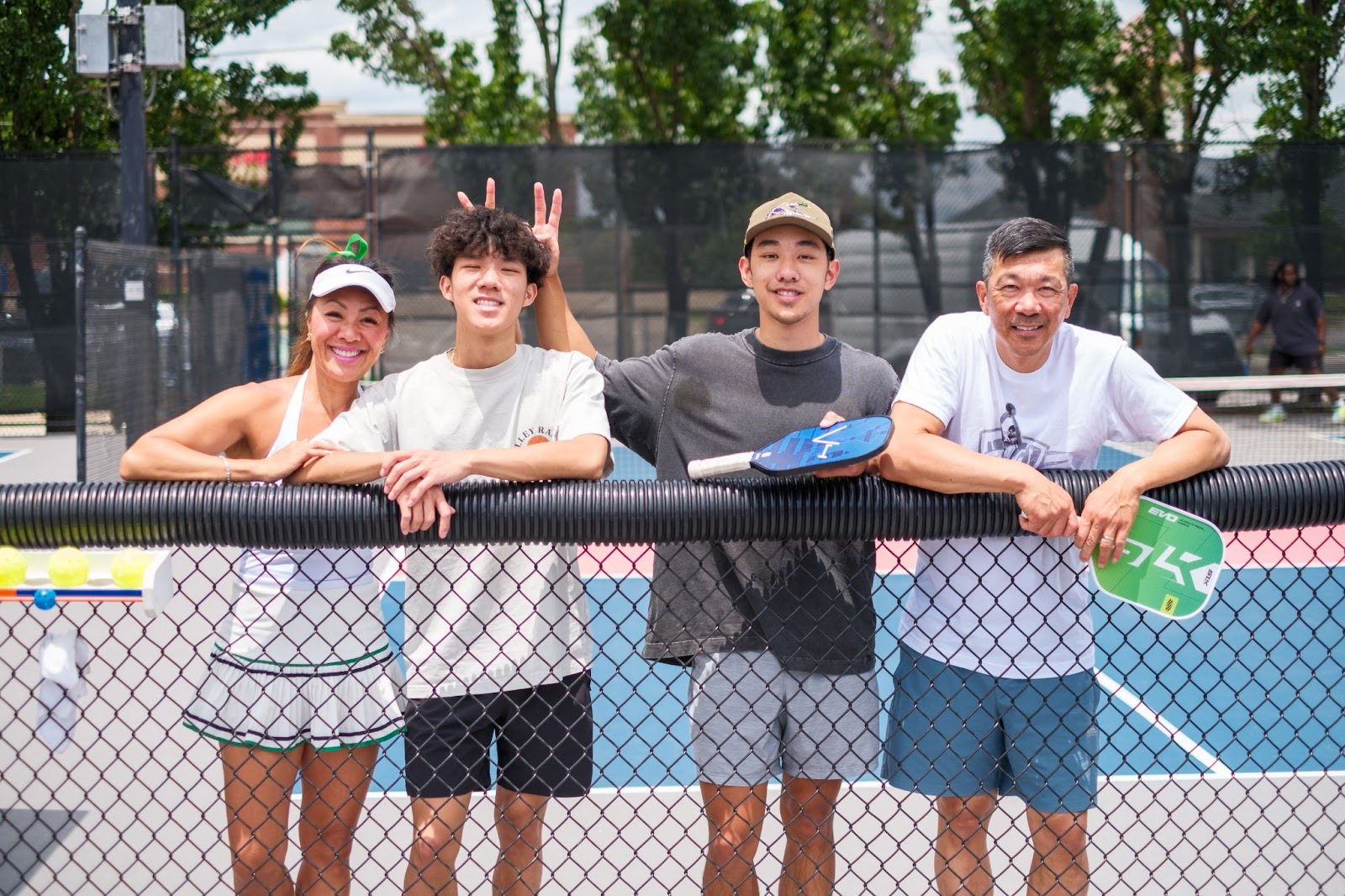 Mary, her husband Kang, and two of their sons pose after a game of pickleball in Edmond, Oklahoma.