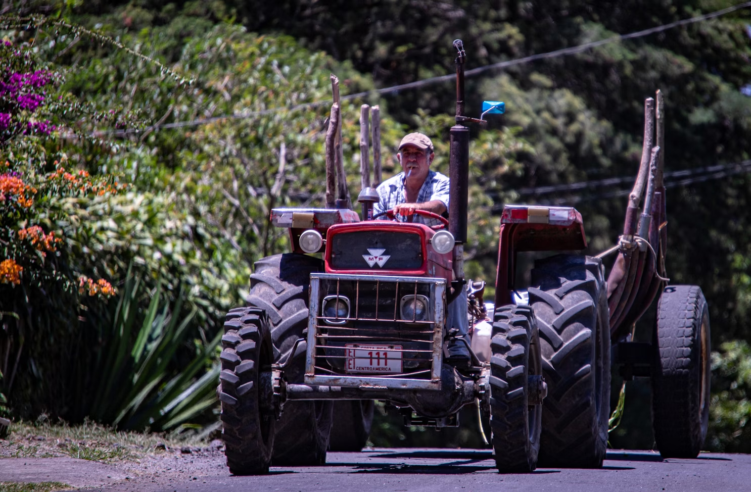 A man driving a tractor down the street