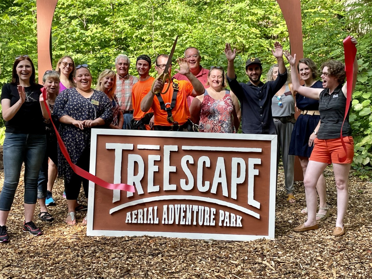 Group of adults at TreEscape Aerial Adventure Park, Vernon, NJ wearing harnesses and helmets, ready to begin their zip line and ropes course adventure.