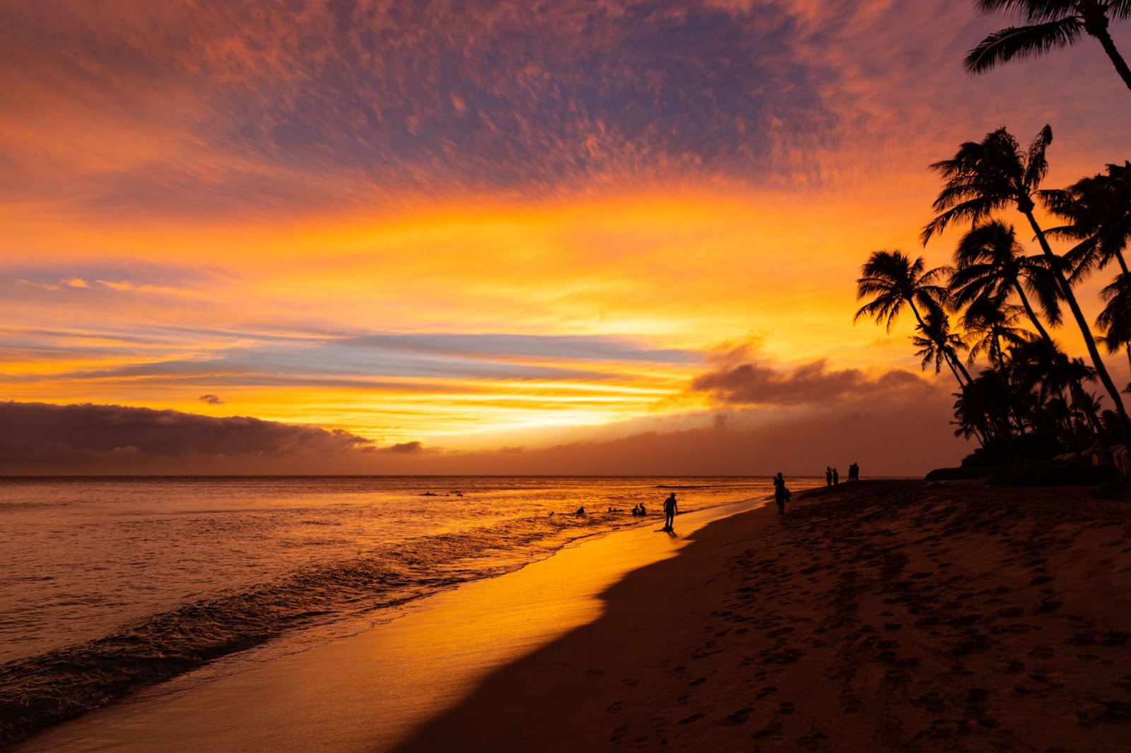 Sunset on a Maui beach with golden skies.