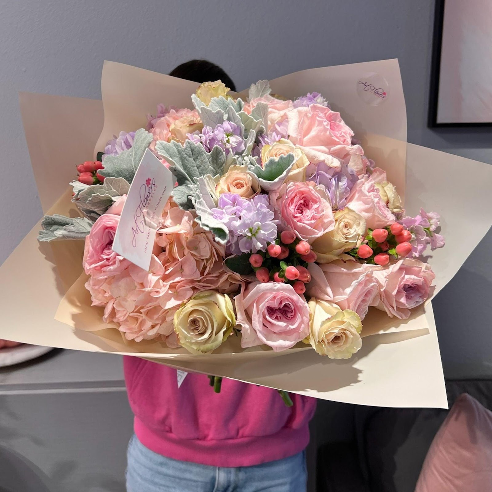 A beautiful arrangement featuring hydrangeas, garden roses, roses, coffee beans, stock flowers, and dusty miller, combining floral elegance with a unique touch of coffee for a rich and textured display.