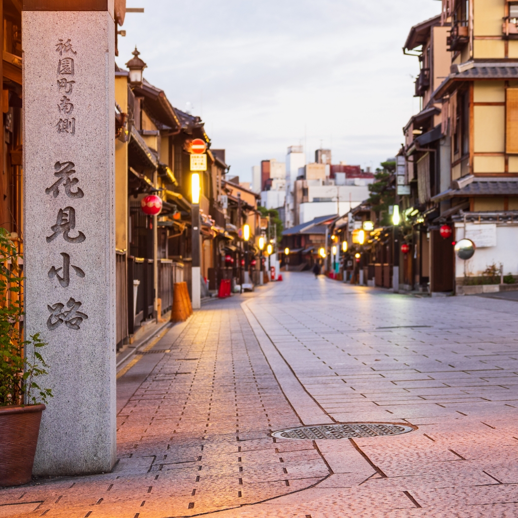 Hanamikoji Street in Gion Kyoto at night featuring traditional ochaya tea houses with wooden facades and lantern illumination for kimono photography