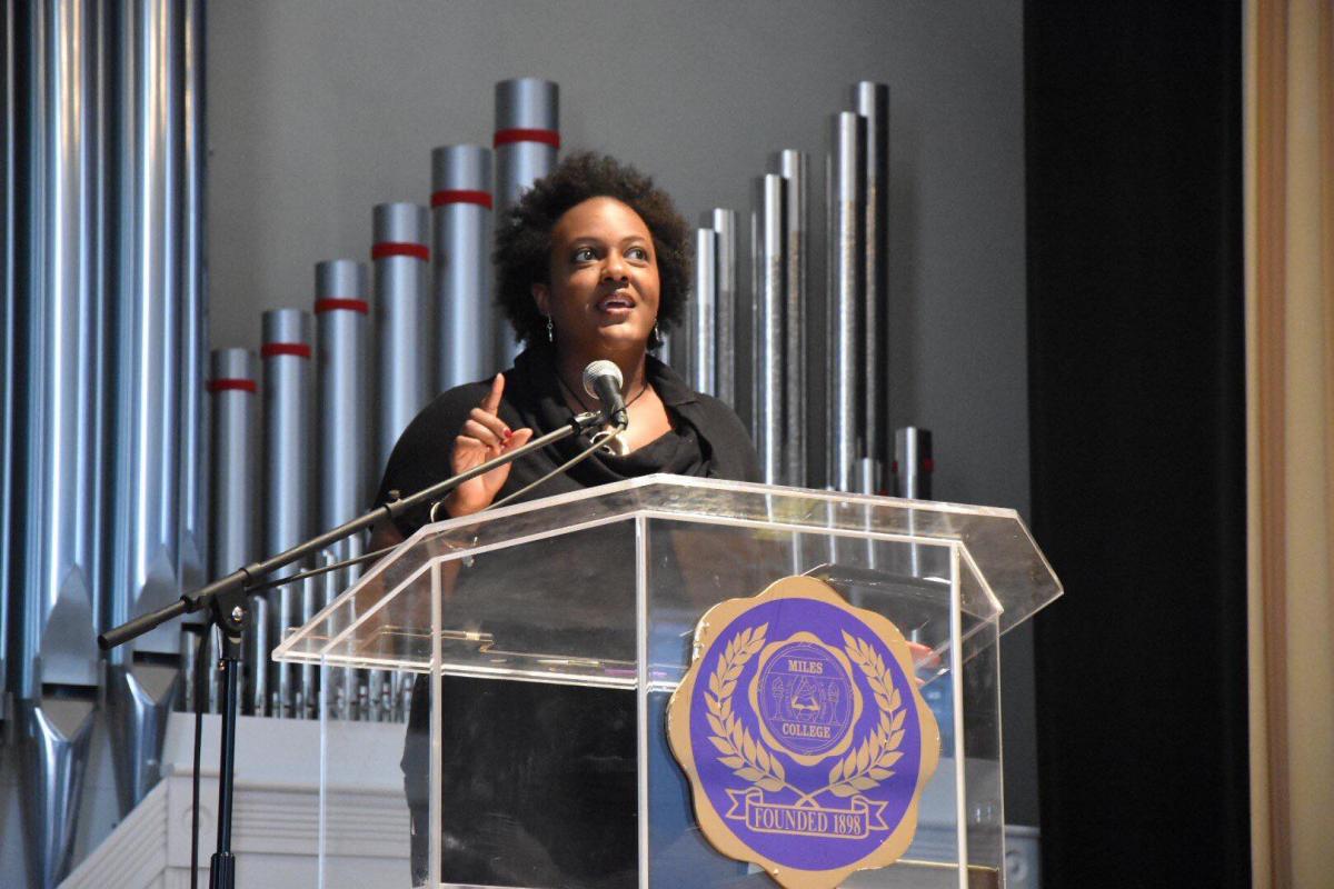 Heather McTeer Toney speaking on stage in front of a podium at Miles College.