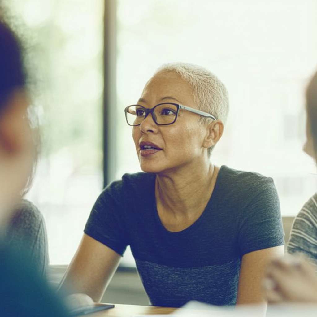 Leader addressing bias and resistance during a 360-degree feedback session in a modern office setting, fostering an open and objective assessment environment.