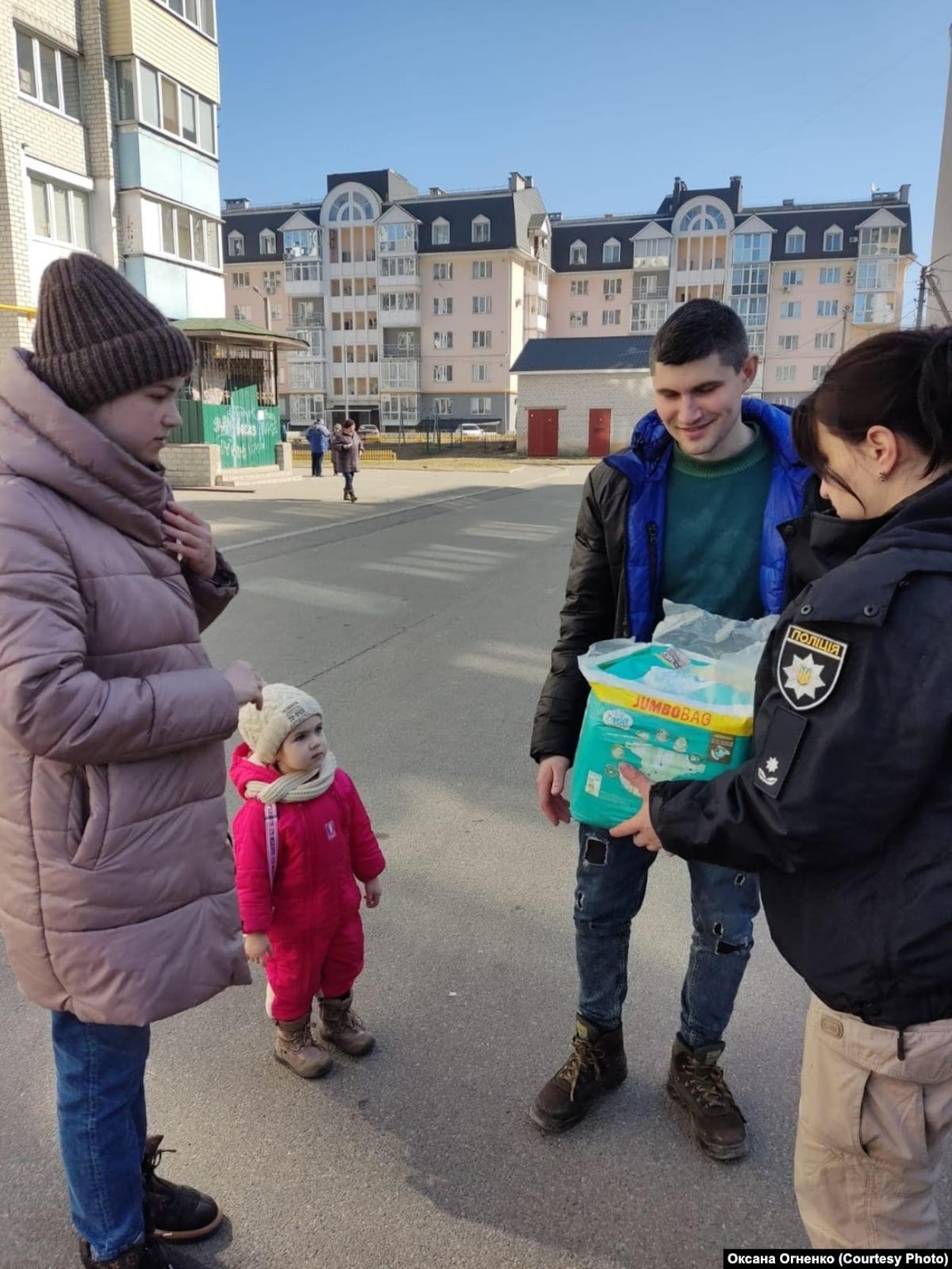 A group of people standing on a street

Description automatically generated