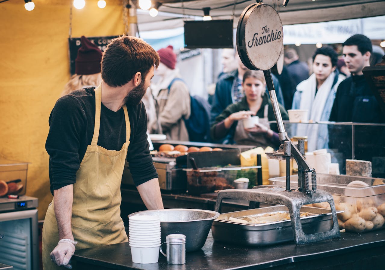 Vendor at a local food market looking at customers, ready to serve, promoting your business locally.