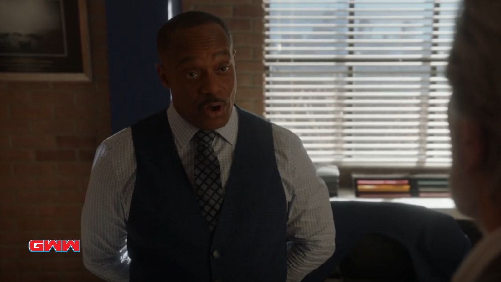 Director Leon Vance in a formal vest and tie speaks in a well-lit office.