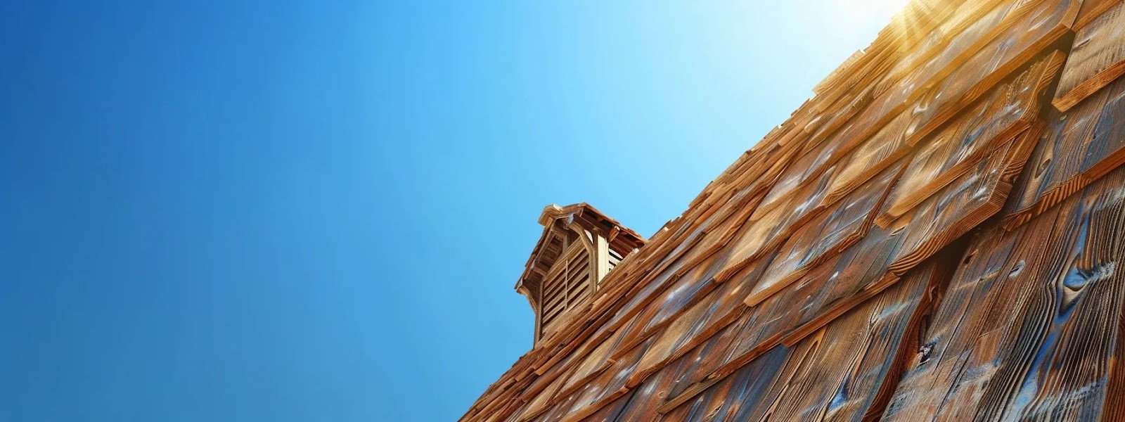 a rustic cedar shake roof under a clear blue sky, blending seamlessly with the natural surroundings.