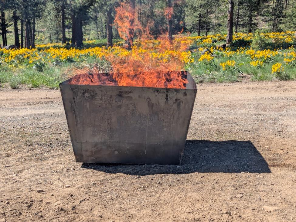 A fire in a square container

AI-generated content may be incorrect.