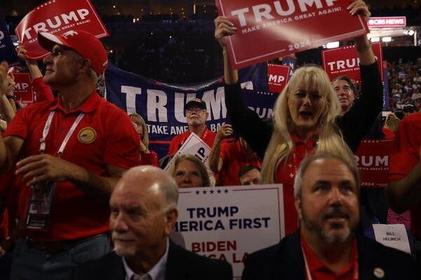 At the Republican National Convention, Trump supporters wave signs that read “Trump America First” and “Trump Make America Great Again.”