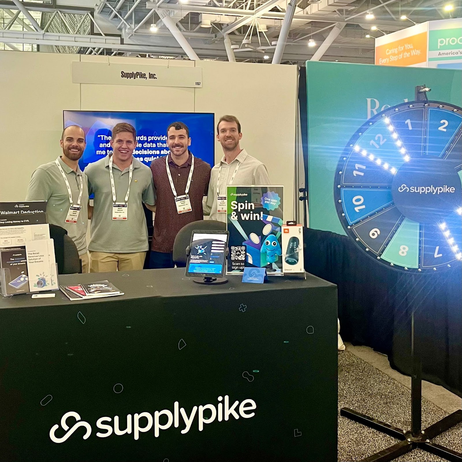 SupplyPike sales team, Hunter, Brent, Nate, and Tyler, standing at their booth at a tradeshow