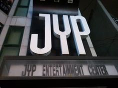 This contain: the jyp entertainment center sign in front of a building