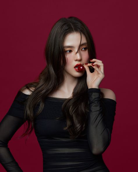 This contain an image of Han So Hee putting on black dress with fruit in her mouth