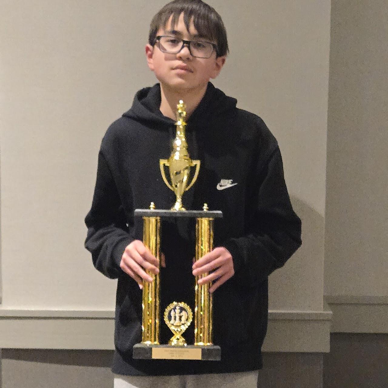 A child holding a trophyDescription automatically generated