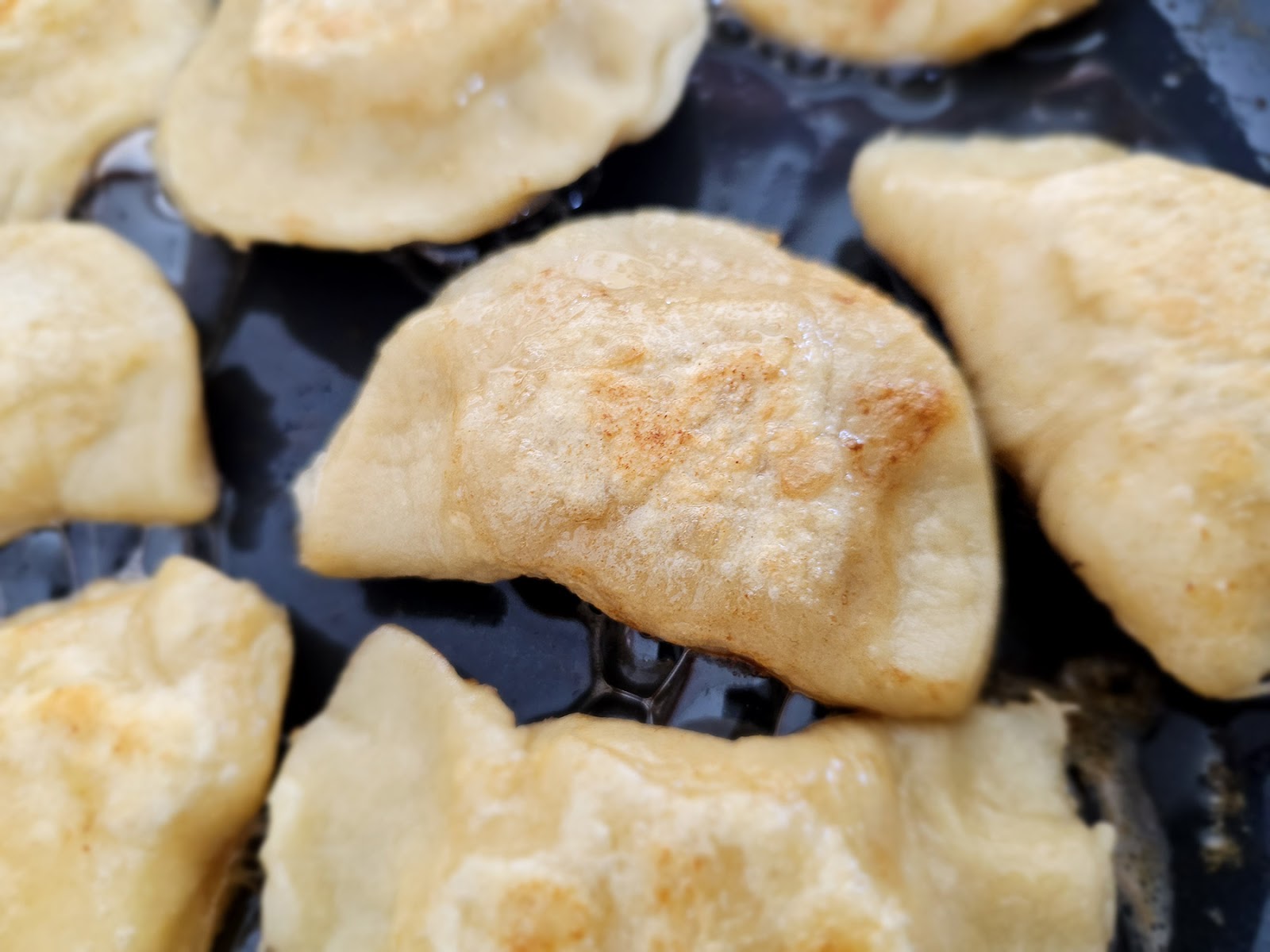 Pierogi frying on a griddle