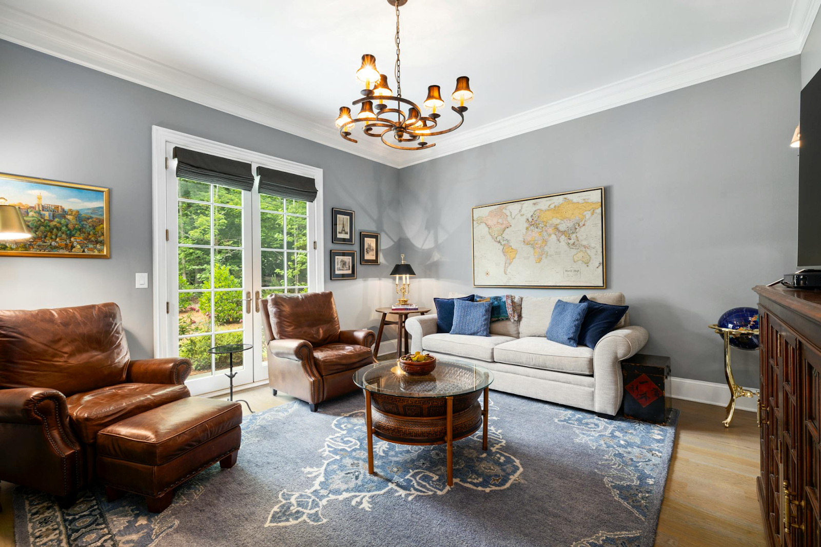 This image depicts a living room with white French doors letting in natural light.