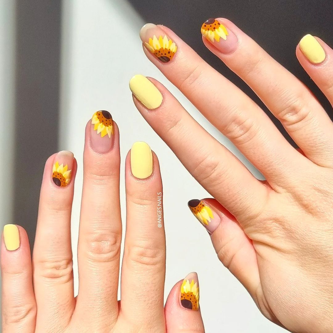 Close-up of hands with fall nail design having Sunflower Nail Art