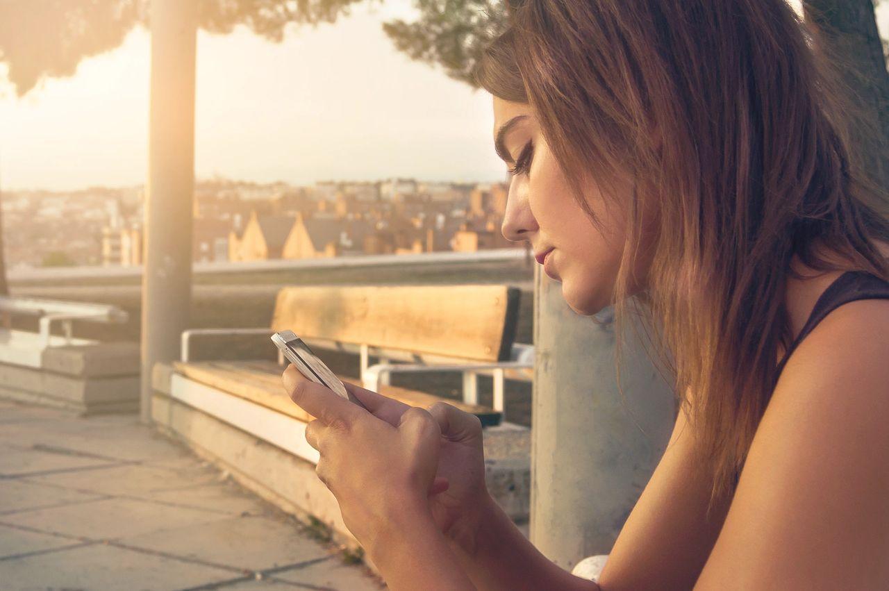 young woman with dark hair on her smart phone