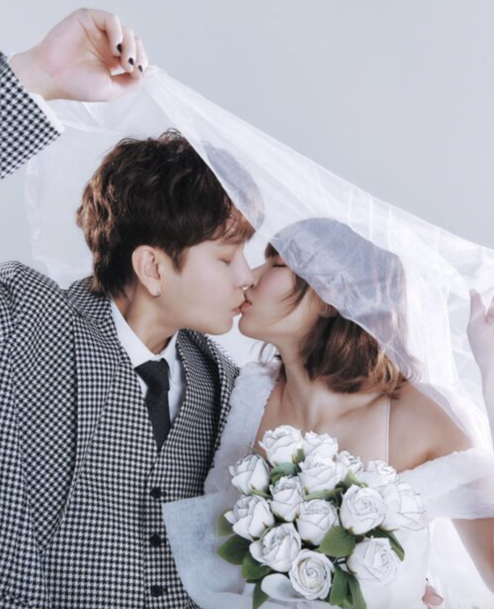 A photo of  HyunA and Yong Junhyung kissing on their wedding day