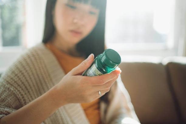 A woman holding a bottle of berberine supplement in her hand, emphasizing health and wellness.