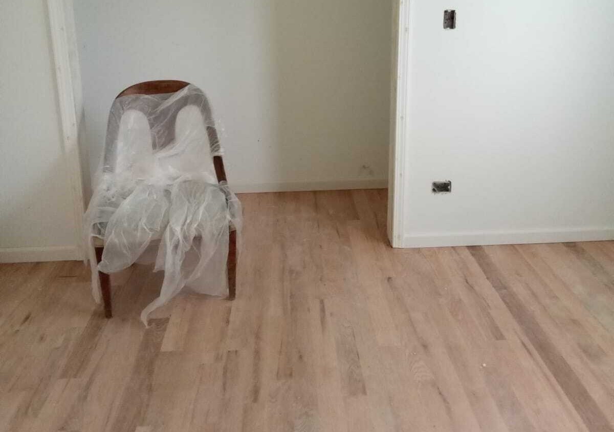 A wooden chair covered in plastic.