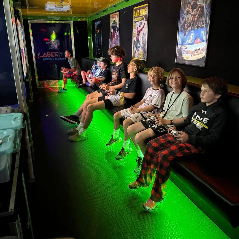 Kids at signature sports camp are enjoying a mobile video game truck during down time at camp