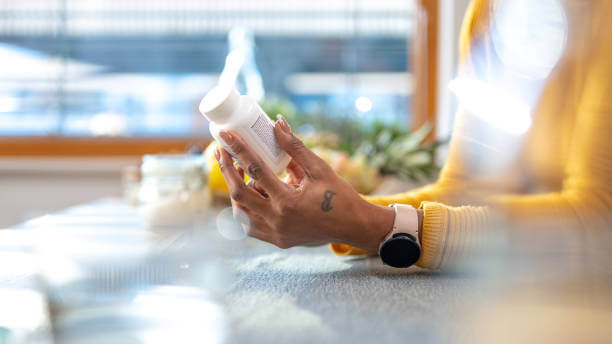 A woman carefully reading the label on a bottle of gut health supplements, ensuring the product meets her health needs.