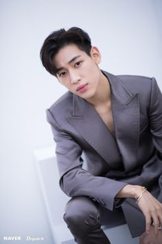 This contains an image of BamBam's in a suit sitting down