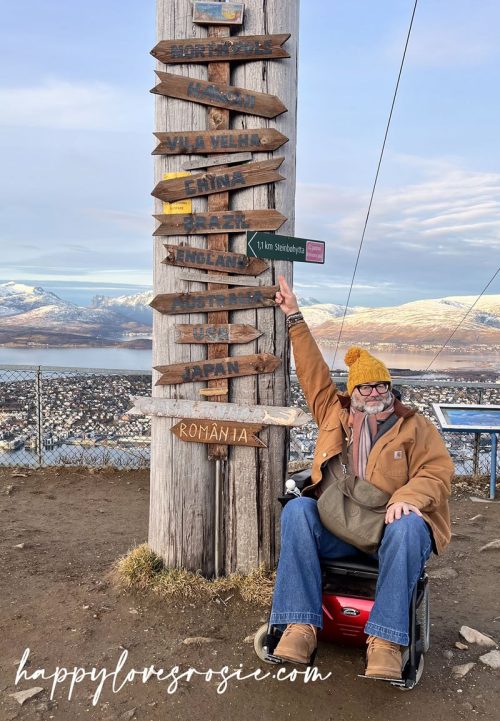 man pointing at makeshift destination signs