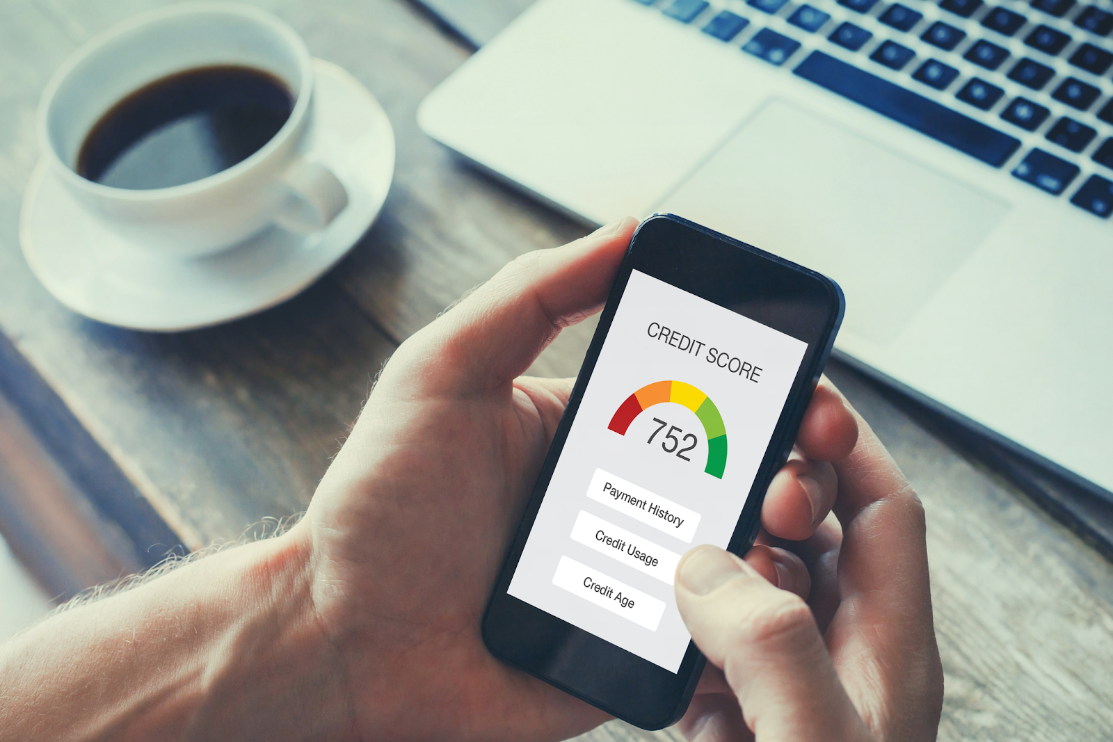 Hands checking credit report displayed on a phone's screen with a score of 752